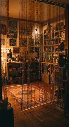 the room is filled with lots of items and has many shelves on each side that have beads hanging from them