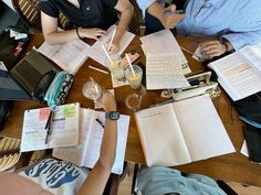 people sitting at a table with notebooks and papers