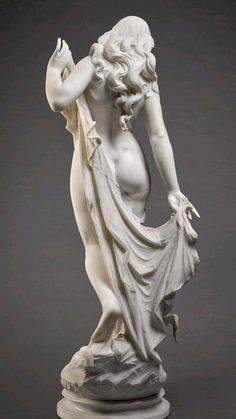 a statue of a woman with her hands in her hair and wearing a flowing dress