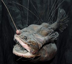 a large fish with its mouth open and some hair on it's back end