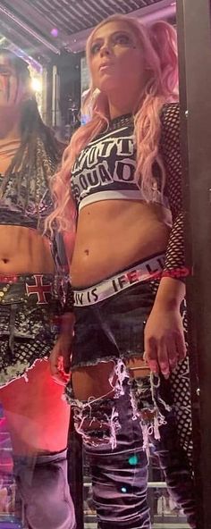 two women standing next to each other in front of a mirror with their hands on their hipss