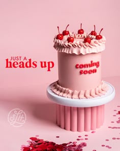 a pink cake sitting on top of a table next to confetti sprinkles