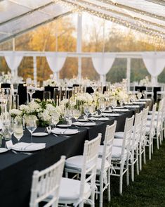 an outdoor tent with tables and chairs set up for a formal dinner or banquet event