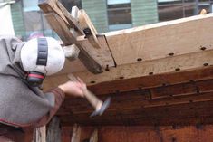 a man is working on a wooden structure