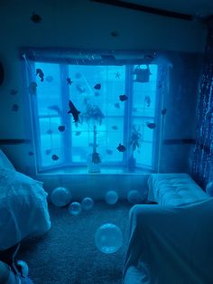 a bedroom with blue lights and fish in the window