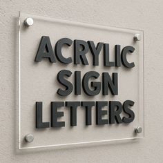 the acrylic sign letters are mounted on the side of a white building with black lettering