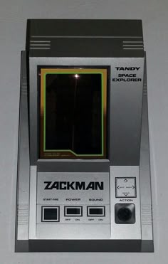 an old style computer game sitting on top of a white table next to a wall