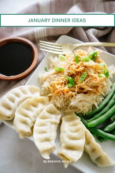 a white plate topped with dumplings and green beans