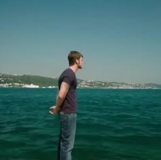 a man standing on top of a pier next to the ocean