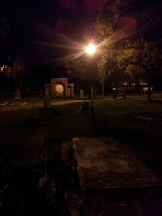an empty park at night with the lights on and no one in it or someone out