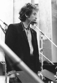 black and white photograph of a woman talking on the phone in front of microphones