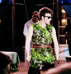 a man in a green dress walking down the street