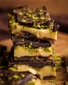 three pieces of chocolate and pistachio dessert on a cutting board