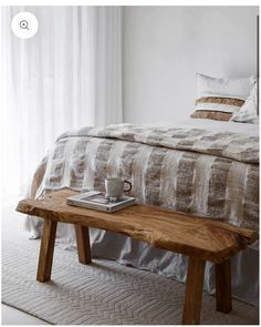 a wooden bench sitting in front of a bed
