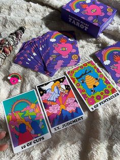 the simpsons tarot cards are being held up by someone's hand on a blanket
