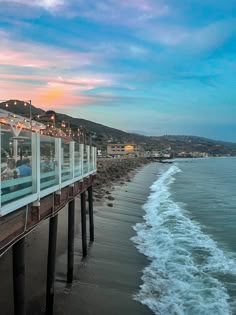 the ocean is next to a pier with glass railings on it's sides