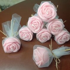 small pink roses are tied with twine and sitting on a table next to each other