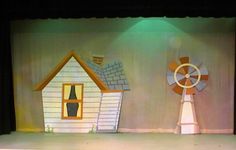 the stage is set for an animated show with windmills and houses on each side