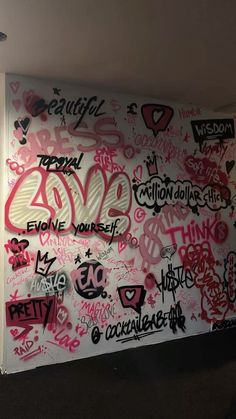 the wall is covered in graffiti and has pink spray paint on it's walls