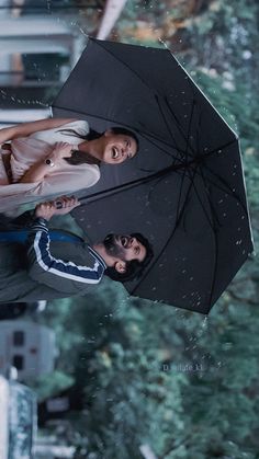 two people standing under an umbrella in the rain