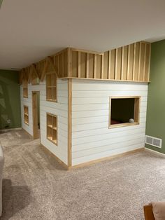 a living room with green walls and a white house shaped like a doll's house