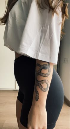a woman with a snake tattoo on her arm