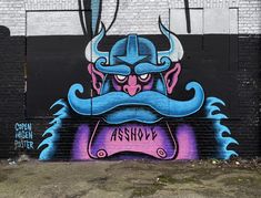 graffiti painted on the side of a building with an image of a demon holding a sign
