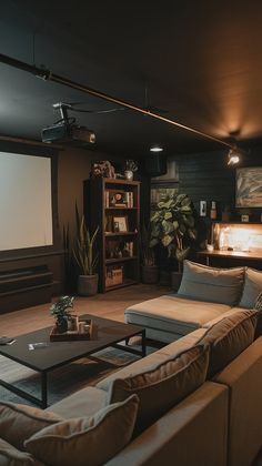a living room with couches, tables and a projector screen in the corner