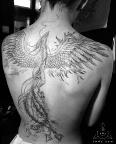 the back of a woman's body with a bird tattoo on it