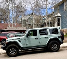 a light blue jeep parked on the side of a street