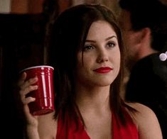 a woman in a red dress holding a cup