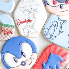 some cookies with different designs on them sitting next to each other in the shape of cartoon characters