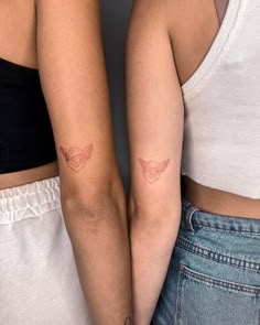 two women with matching tattoos on their arms