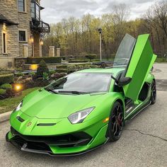 a green sports car parked in front of a house