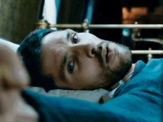 a man laying on top of a bed in a bedroom