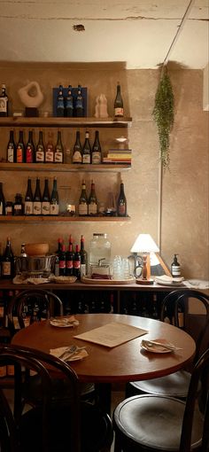 there are many bottles on the shelves above the table