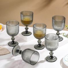 six glass goblets sitting on a table