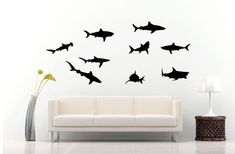 a living room with a white couch and black shark wall decals