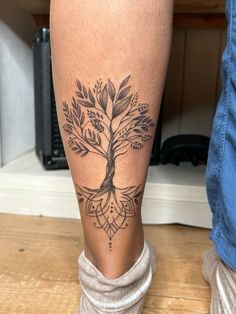 a person with a tree tattoo on their leg