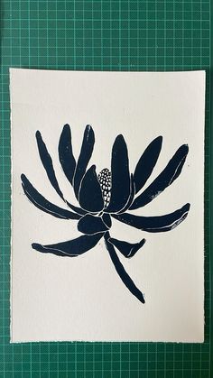 a piece of paper that has been painted with black and white paint on it, sitting on a green surface