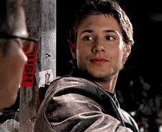 the young man is talking to an older man who is wearing glasses and looking at him