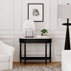 a black and white table with a vase on it next to a chair in a living room