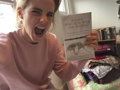 a woman holding up a book in front of her face