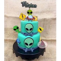 an alien themed birthday cake with stickers on it's top and bottom tier