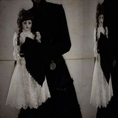 two dolls dressed in black and white standing next to each other
