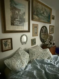 a bedroom with pictures on the wall above the bed