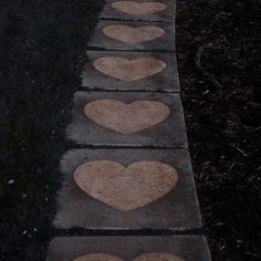 the sidewalk has hearts painted on it and is lined up with concrete blocks in the shape of heart