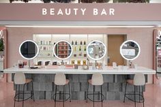 a beauty bar with stools and mirrors
