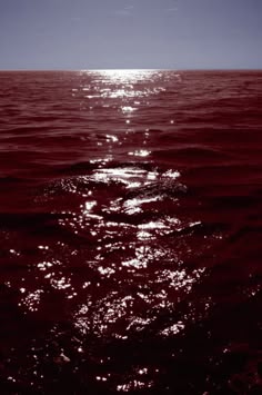 the sun shines brightly on the water as it reflects off in the dark blue sky