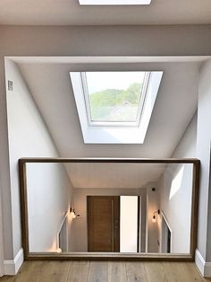 an empty room with wooden floors and skylight above the door, is shown in this image
